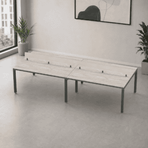 Mesa de oficina moderna con división de acrílico para trabajo colaborativo.
