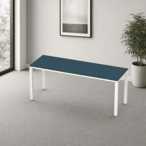 Mesa de oficina moderna con superficie azul y estructura blanca en espacio minimalista.